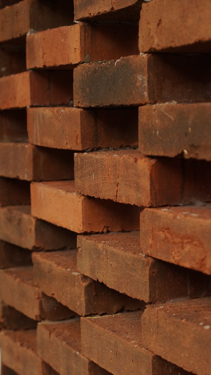 Vertical stack of red clay bricks, ideal for construction and architecture visuals.