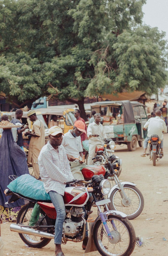Bustling African street market with people and motorcycles in action.